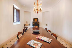 Long dining table, magazines, antique chest, chandelier
