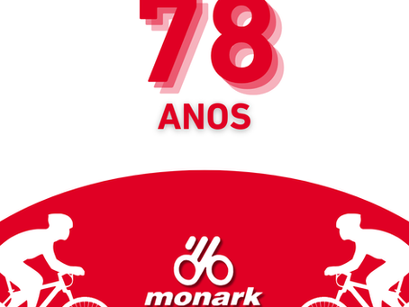Post celebrando aniversário da empresa Bicicletas Monark SA, com ciclistas em silhueta branca sobre fundo vermelho. Texto: "78 anos" em vermelho e sombra. Logotipo da Bicicletas Monark  SA no centro.