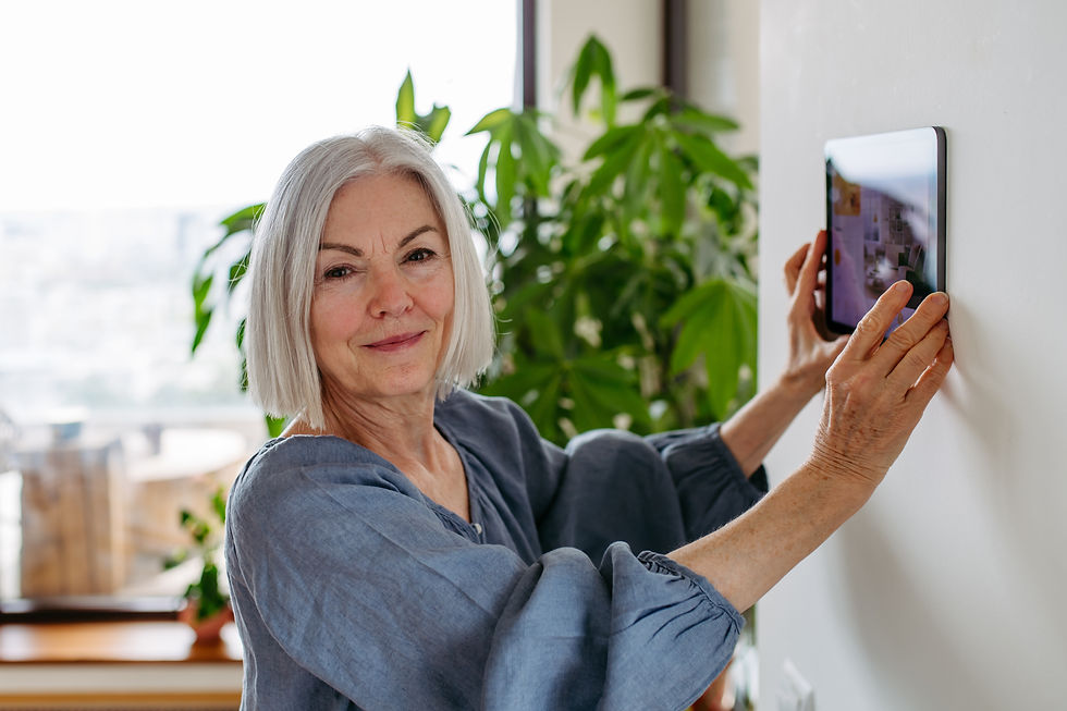 A senior woman smiles as she uses her smart thermostat