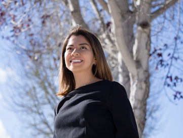 confident and smiling hispanic female grad student photoshoot