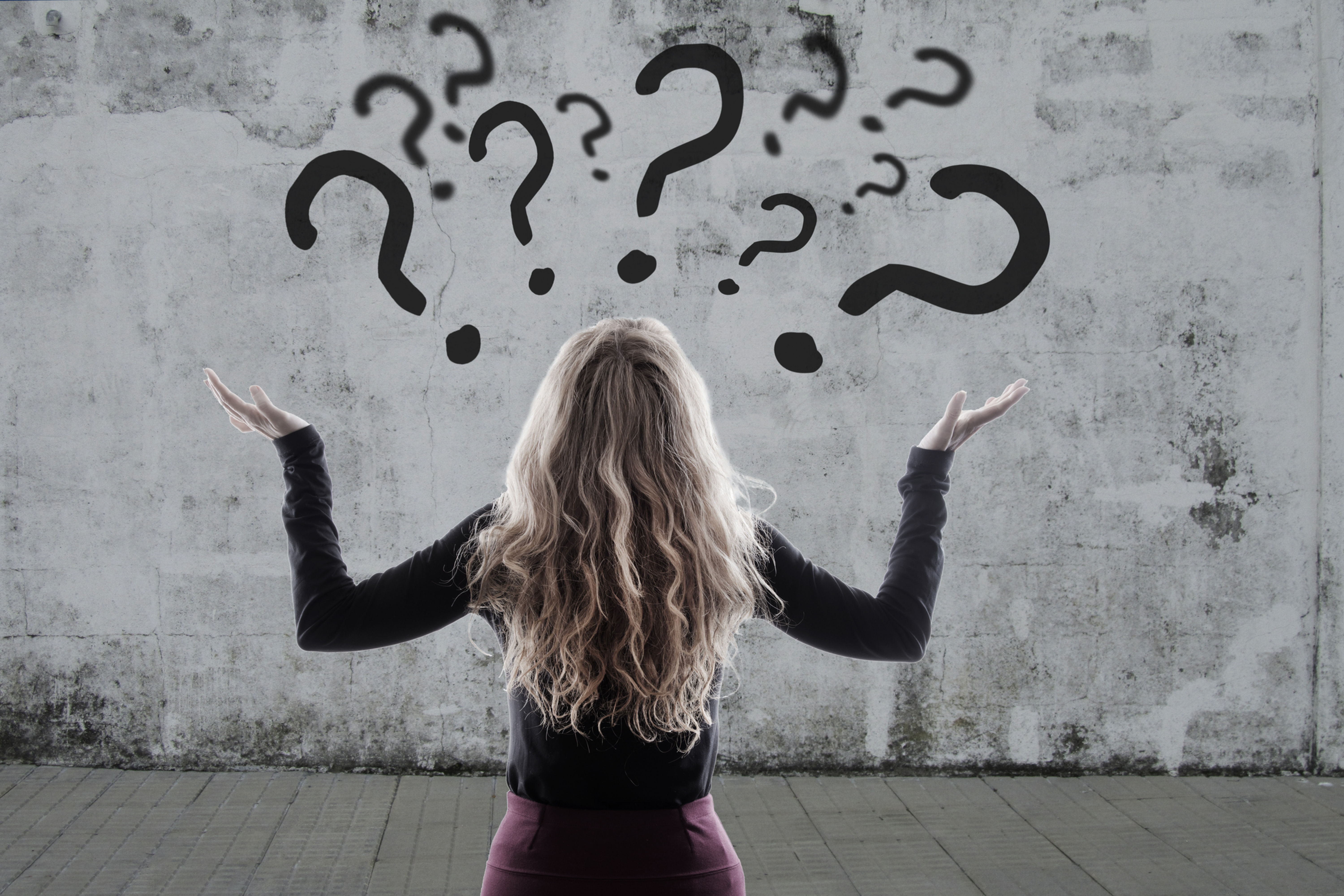 Woman holding her hands up in uncertainty, surrounded by floating question marks—visually representing the energy of indecision for a tarot decision-making reading.