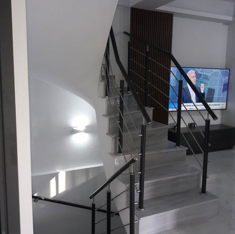 Μοντέρνο κάγκελο σκάλας από inox και ηλεκτροστατική βαφή για minimal εσωτερικούς χώρους.