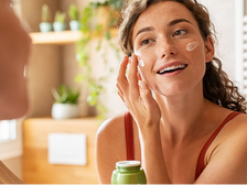 Woman applying hydrating face cream after a sunny vacation to restore moisture and calm dry skin