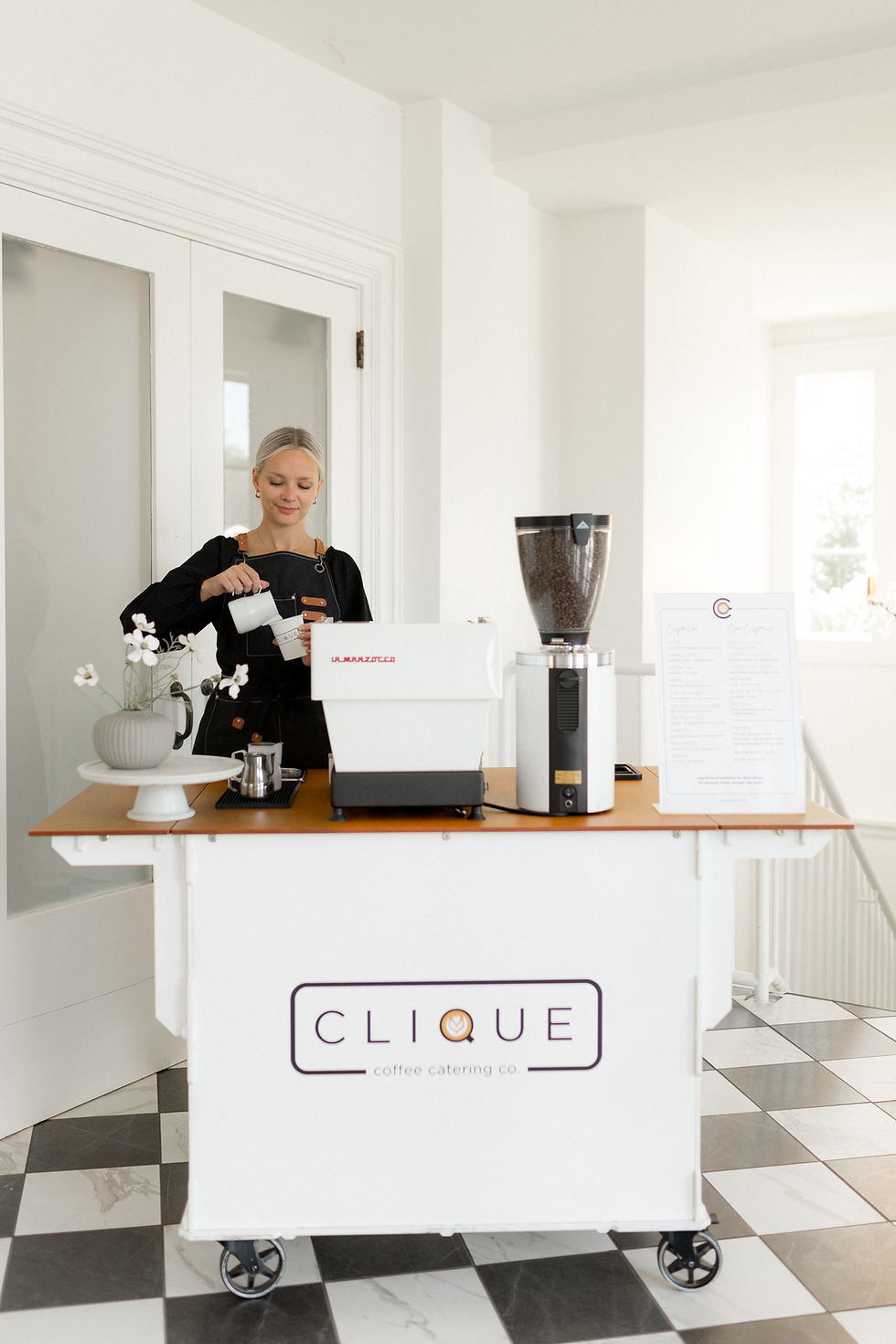 Clique barista pouring a drink in an elegant venue with a beautiful backdrop