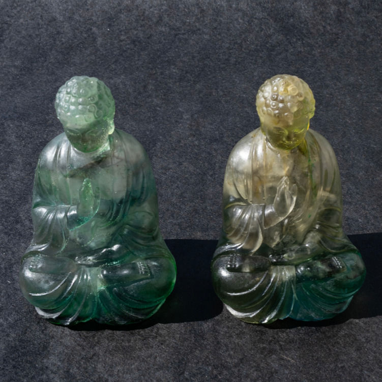 Front view of two orgone Green sitting Buddhas with hand raised in sign of blessing