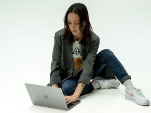 Marketing professional typing on a Mac laptop.