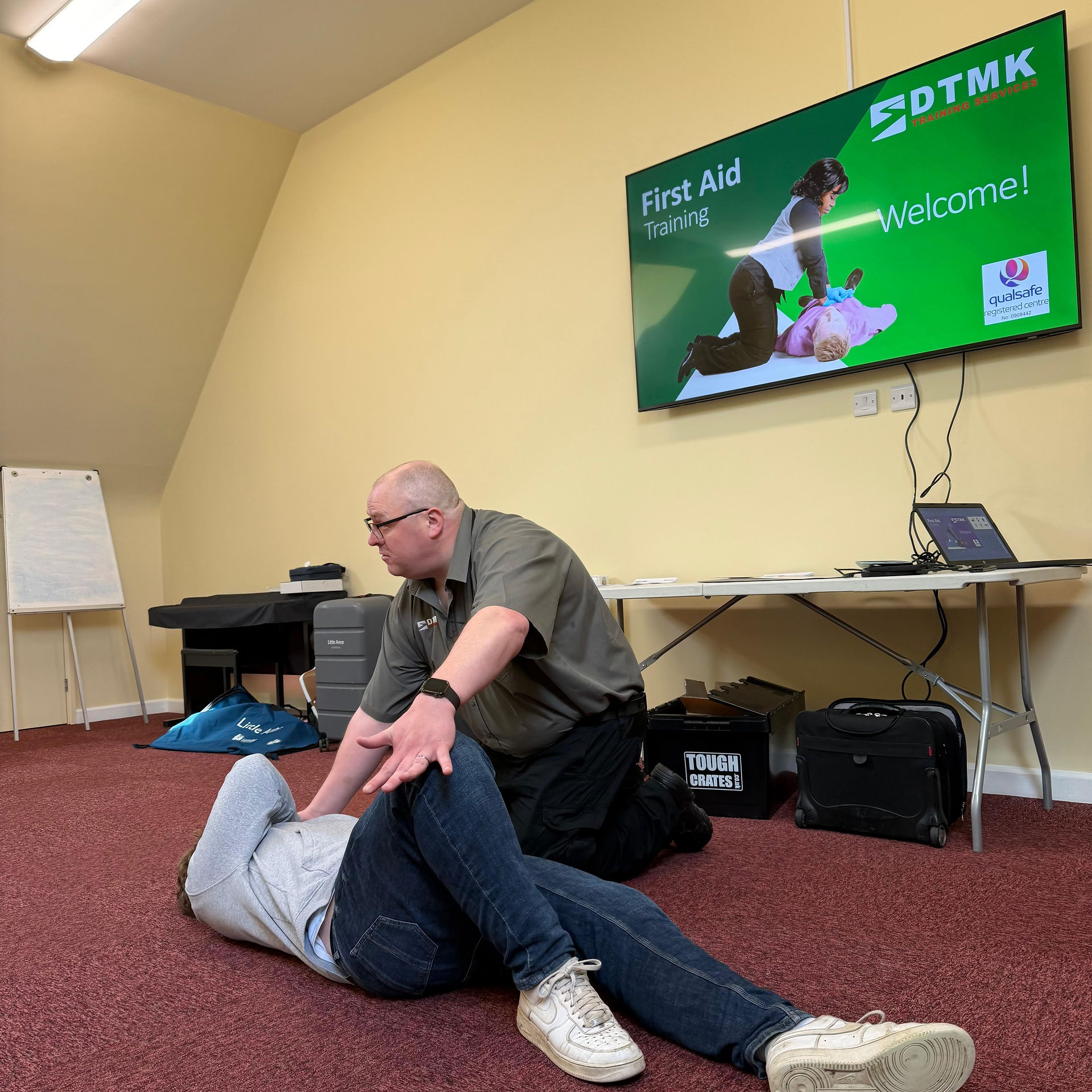 First aid trainer demonstrating the recovery position during a DTMK training course in Milton Keynes