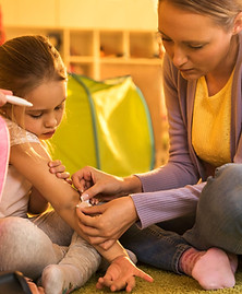 Adult providing first aid to a child with an injured arm