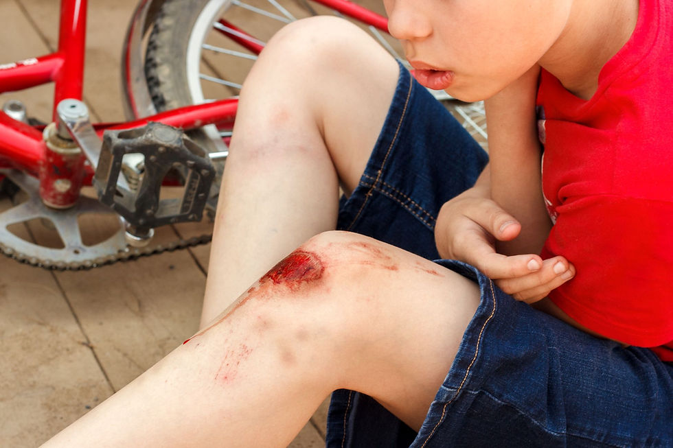 Young child with a grazed knee receiving first aid after an injury.