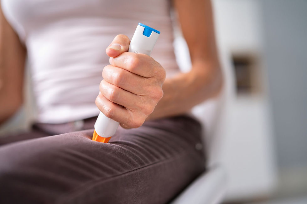 Adrenaline auto-injector being demonstrated on a person’s outer thigh