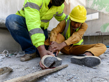 Construction worker providing first aid to an injured colleague on a building site