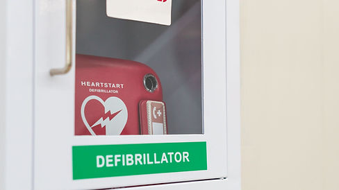 Heartstart defibrillator visible inside a wall mounted cabinet with clear signage.