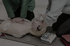 Learners practising adult CPR with a bag-valve mask and AED during Clinical BLS training