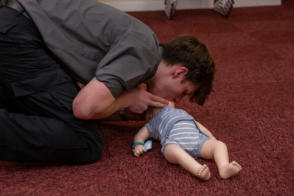 Learner practising infant CPR on a manikin during an all-ages BLS course.