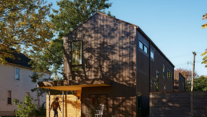 Located in the North Corktown Neighborhood of Detroit, Michigan, the Cochrane Home is a two-story, 1,800 SF three bed and two bath single-family home.
This project includes a 430 SF detached single-car garage that can be accessed by an alleyway from the main home. It also includes an in-law suite above the garage that provides an additional 430 SF. This room can be accessed from the main house by a second level bridge.
The construction of this house includes IVB Steel and wood envelope with interior wood and drywall partitions that are semi-protected.
The Cochrane Home is the first project from the houm and Three Squared, Inc. Partnership. With the design and construction of this project, comes the official prototype of the houm product, pioneering a new way of how homes are built.
