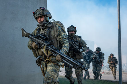 A fireteam moves with urgency and coordination during a simulated urban assault, weapons ready and communication tight. - Thomas Oberdorfer Photography
