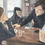 Thumbnail: three bored chinese people wear black shirts and drink and eat in a cafe