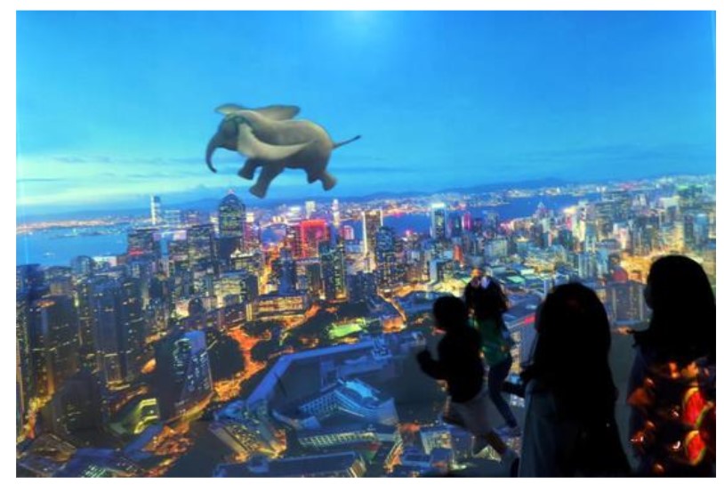 digital image of dumbo on a wall and it looks like dumbo is flying across hong kong at night
