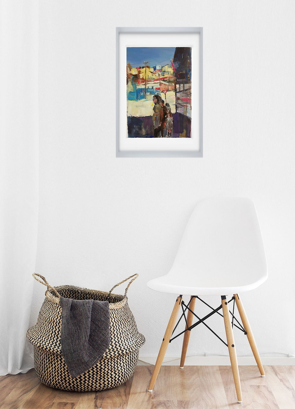 painting on gray wall hangs over white chair and wicker basket