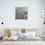 Thumbnail: painting on light gray wall above large bed with multiple white pillows tan bed sheets blanket