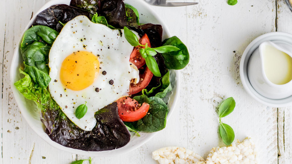 Mock fried egg on fresh dark green bed of lettuc. 