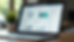 Close-up view of a laptop screen showing a real estate CRM dashboard with client data and property details