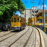 Bonde amarelo histórico cruzando os Arcos da Lapa em direção ao bairro de Santa Teresa no Rio de Janeiro.