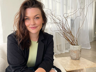 Smiling woman with brown hair in a black blazer.
