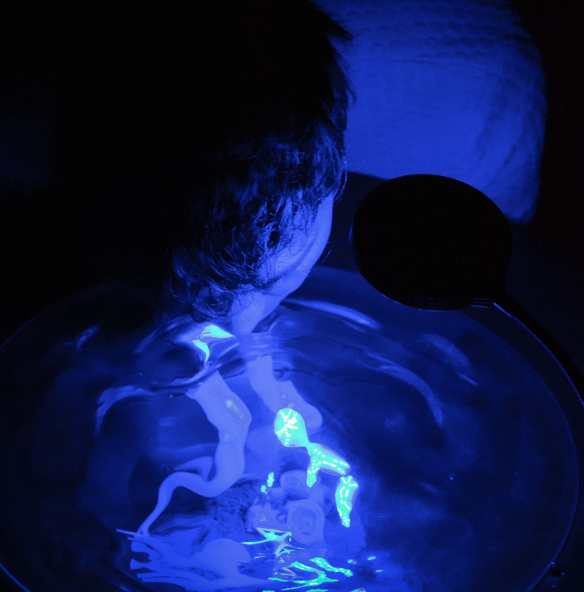 person holds mouth up to glass chamber 