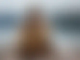 Ein Pfahlbauernmädchen sitzt auf einem rauen Holzsteg und schaut auf den Zürichsee und die nebelverhangene Hügelkette am anderen Ufert, Bild zur Kurzgeschichte Aina der Reihe "Schweizergeschichten"