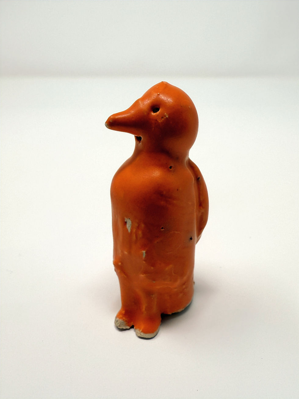 Thumbnail: Small bird sitting with wings on back in orange