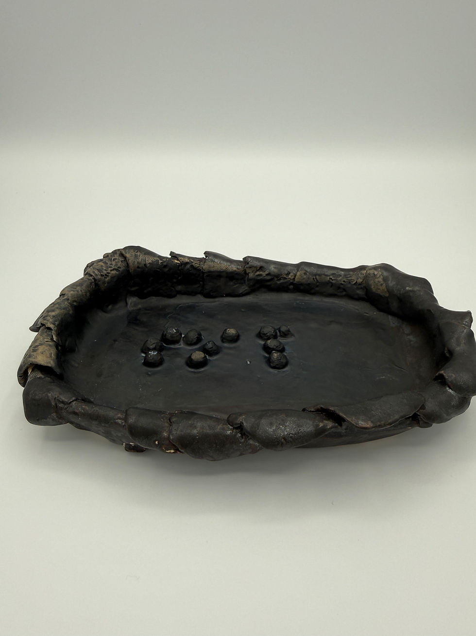black glazed soap dish with soap written in braille