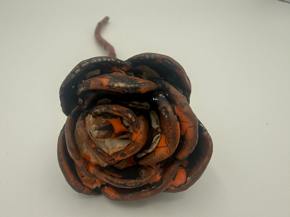 hand built rose in black and orange glaze with wooden brown stem