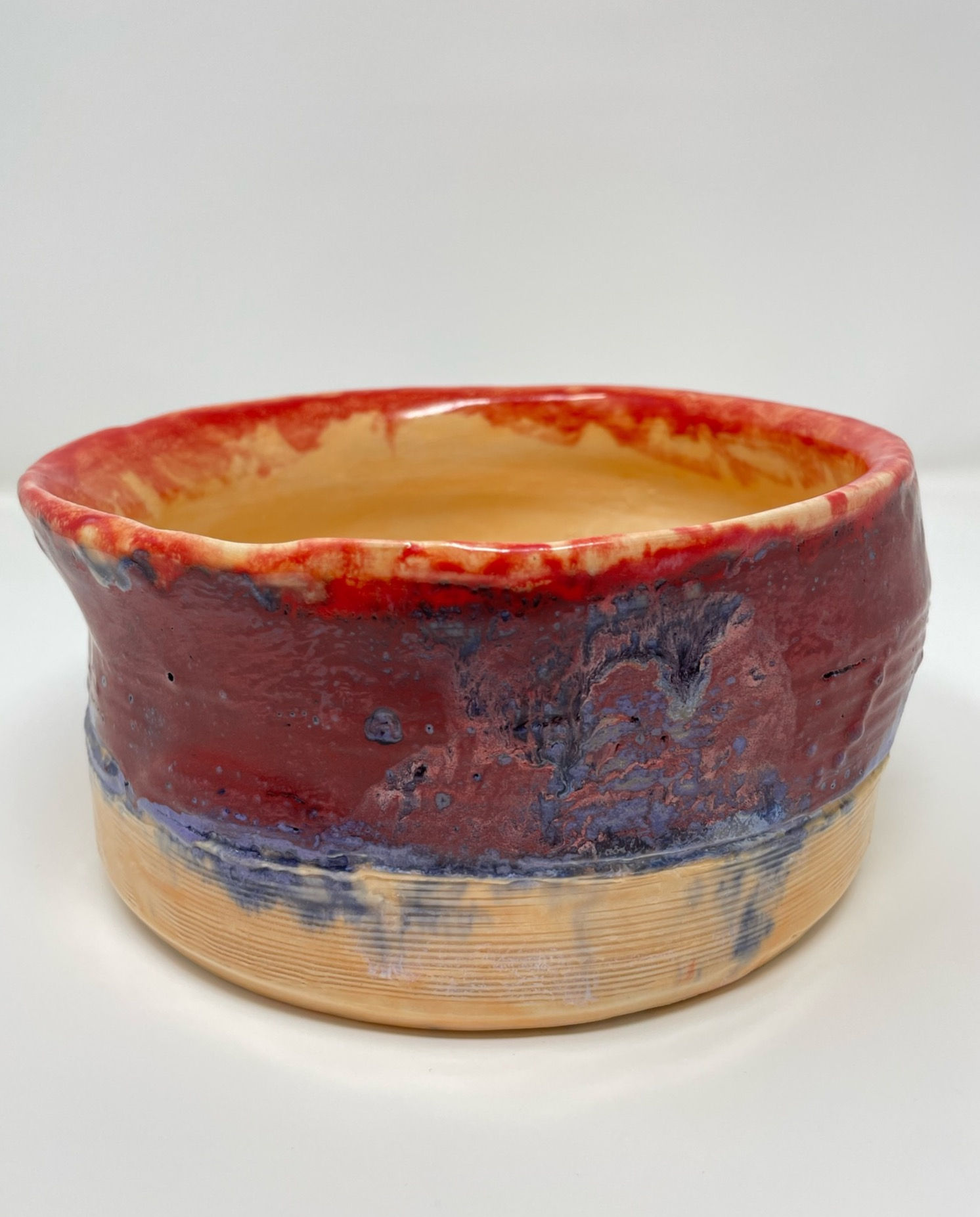 Crater like textured bowl in peach, lavender and red prism