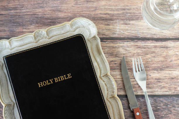 The Holy Bible on a plate with fork and knife