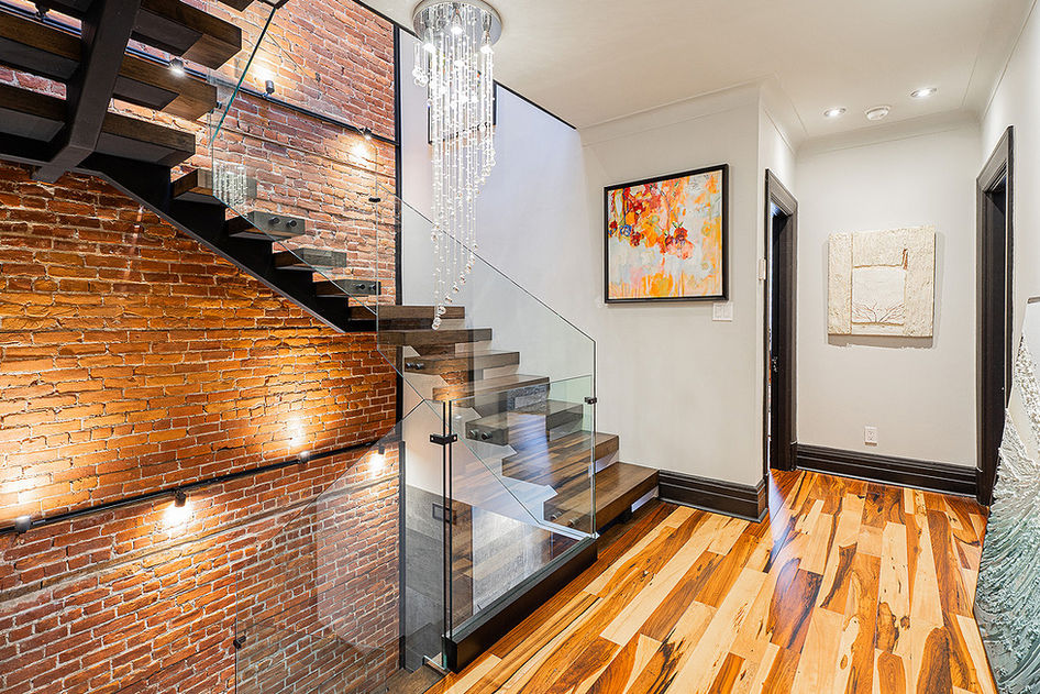 Intérieur moderne avec escalier en bois, mur de briques apparentes et décoration, Location Prive