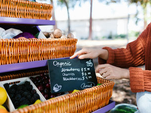 Close up of hands setting up the price board on a farmers market stall. 