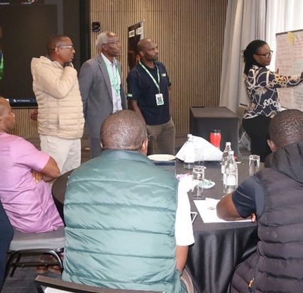 Group of people develop a brainstorming activity on a whiteboard during workshop in hotel conference room.