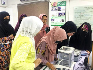 Young Muslim women interning at a lab with CABI Pakistan.