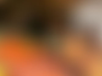 Market scene with a vendor handing vegetables to a woman. Colorful produce surrounds them. Both appear engaged in conversation.