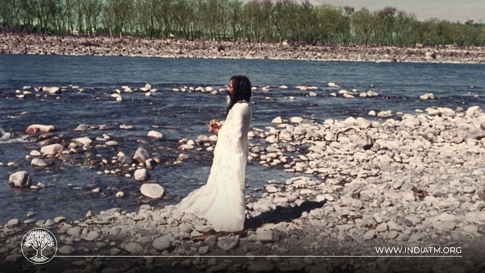 Maharishi Mahesh Yogi Stading on a River Bank