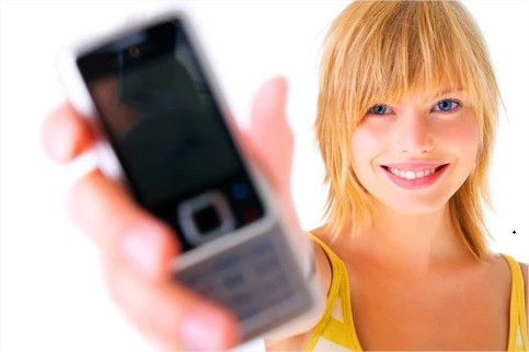 Une femme tenant son mobile.