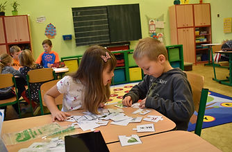 Spolupracující kluk s holčičkou třídí obrázkové karty
