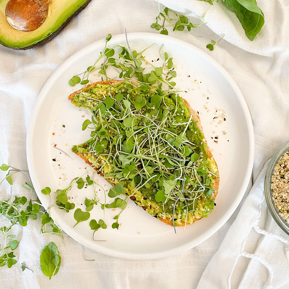 Sourdough bread topped with avocado, pesto, hemp seeds, and microgreens