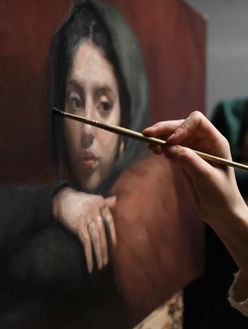 Woman painting a portrait painting close up on the brushstroke.