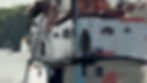 Colorful boats docked at a harbor, with blurred nature in the background. The scene is calm and vibrant, featuring varied hues and textures.