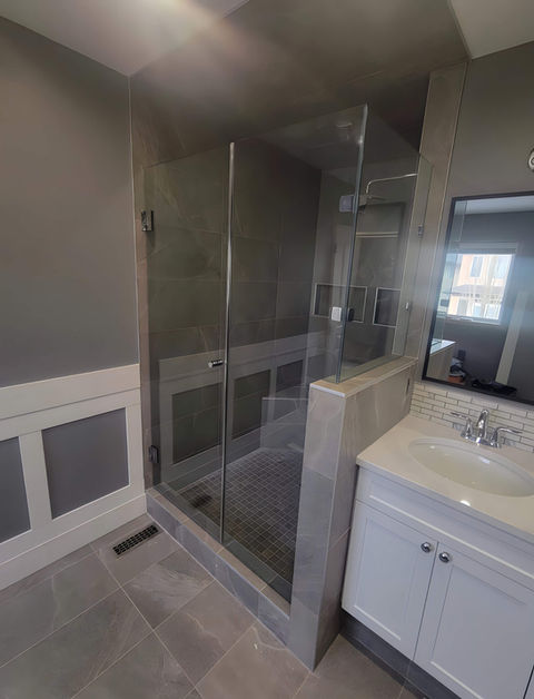Glass shower with a white sink to the right.