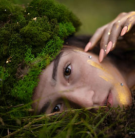 Forest photoshoot featuring a dryad among moss and golden sparkles, capturing magical, mystical, and serene natural beauty.