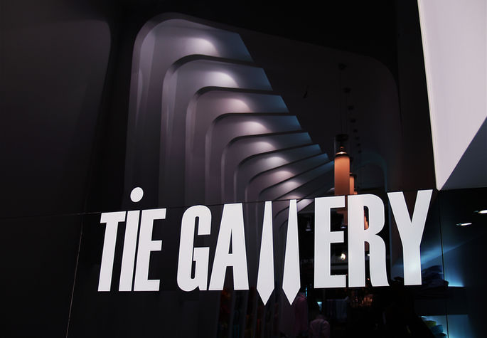 Logo of modern retail store interior with curved white ceiling and illuminated shelving displaying shirts and ties by99 01 architects.