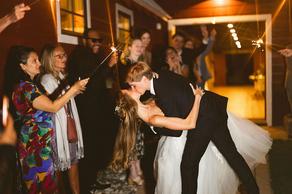 Bride and groom kissing during their wedding reception exit.